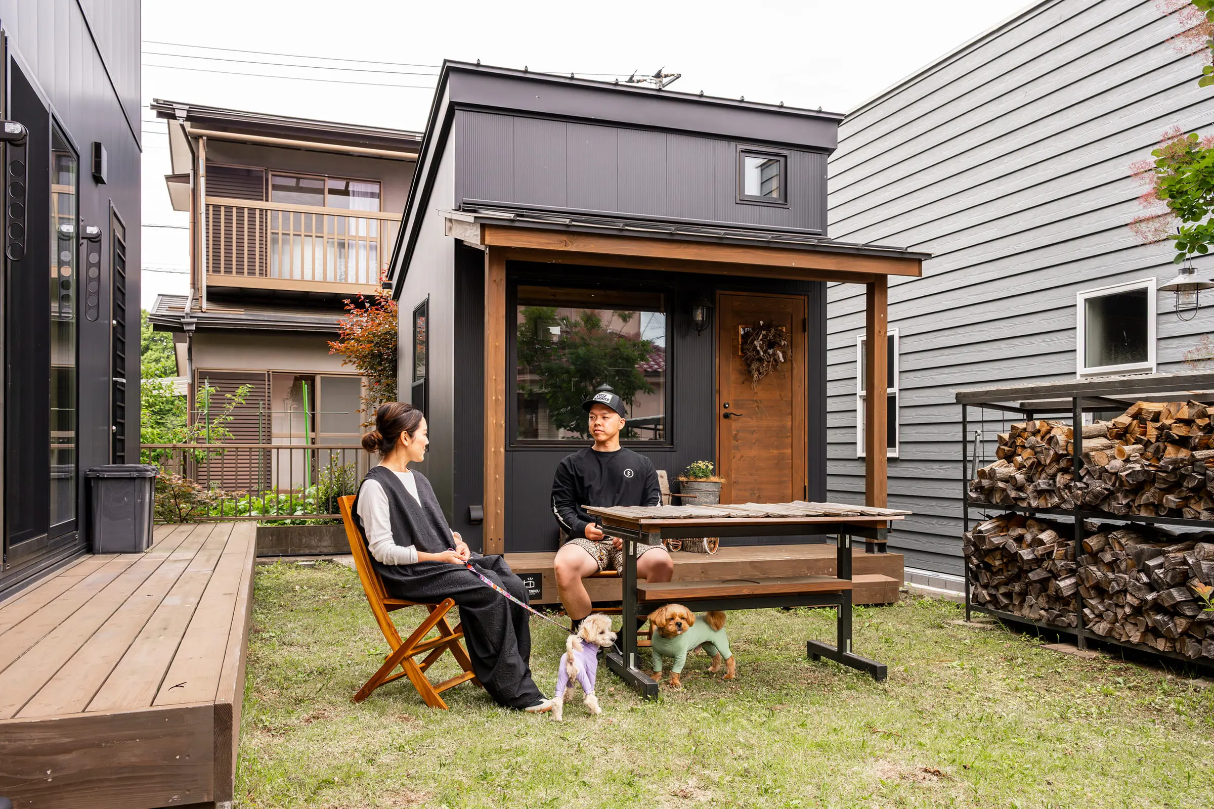 庭のウッドデッキで愛犬とくつろぐ夫婦と愛犬