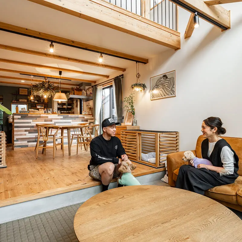 木の温もりを感じるリビングでくつろぐ夫婦とペット