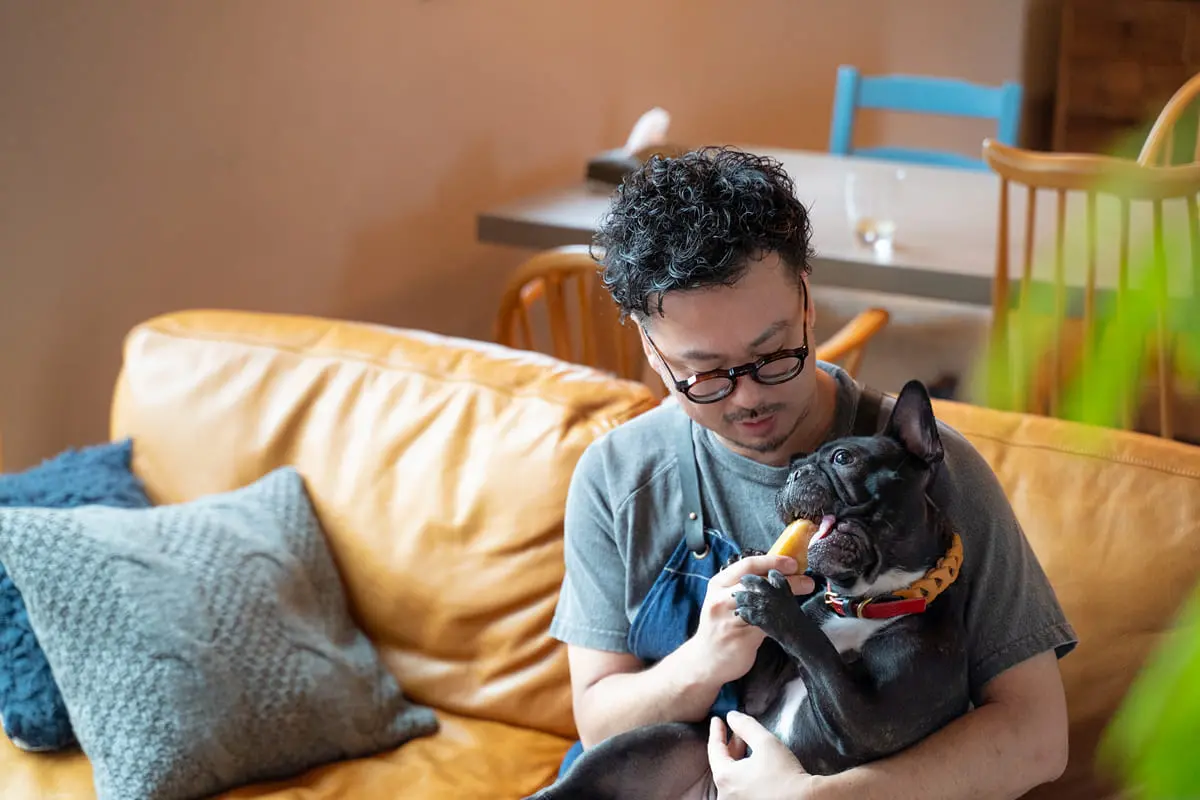 ソファで愛犬を抱きくつろぐ男性